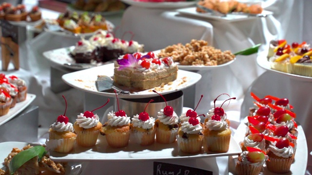 在酒店柜台上展示的盘子中各种甜点的淘金镜头，在餐厅自助餐期间的新鲜甜食的特写-蒙特哥湾，牙买加视频下载