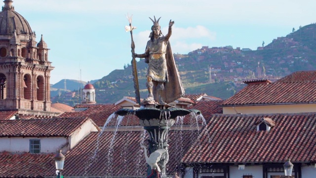 在一个阳光明媚的日子里，在城市屋顶上的雕像在喷泉上的慢动作，男性雕塑在天空的映衬下——秘鲁库斯科视频下载