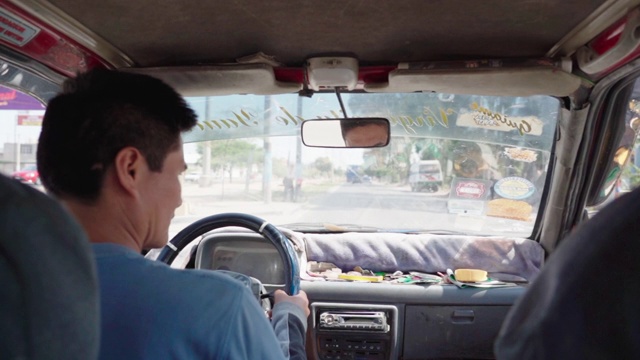 秘鲁瓦卡奇纳，阳光明媚的一天，一名男子在城市街道上驾驶汽车，司机坐在车内视频素材