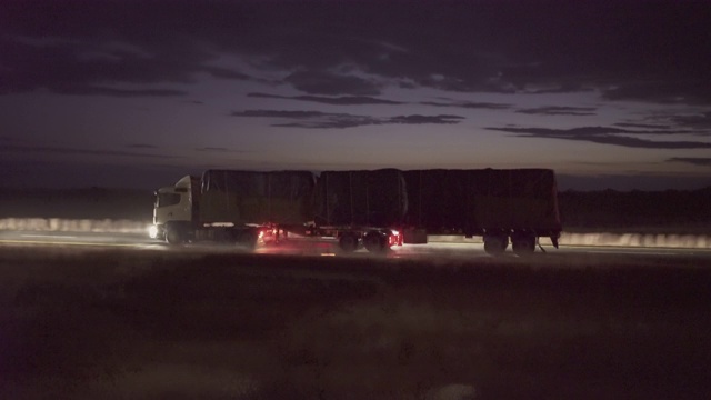 黄昏时，通过火车窗口看到的卡车在道路上移动的平移镜头-斯瓦科普蒙德，纳米比亚视频下载