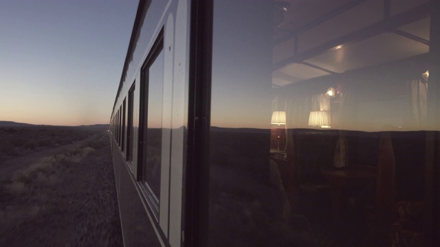 在日落时，风景反射在移动的火车窗户上对着天空-斯瓦科普蒙德，纳米比亚视频下载
