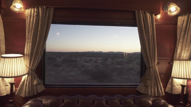 通过豪华的火车窗户在日落时看到的风景，美丽的铁路旅程对天空-斯瓦科普蒙德，纳米比亚视频下载