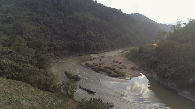 航拍游客在森林中的河流上的船，无人机向前飞向山上的树木-湄公河，老挝视频素材