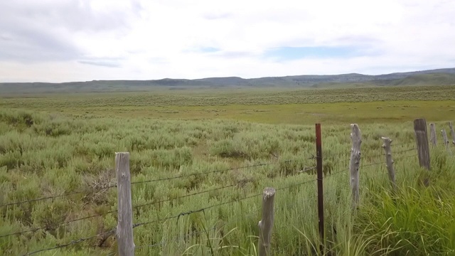 鸟瞰图:环绕着多云天空的篱笆和山脉的绿色景观-博伊西，爱达荷州视频素材