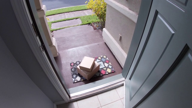 包裹在门外面，门开了，人捡了起来视频素材