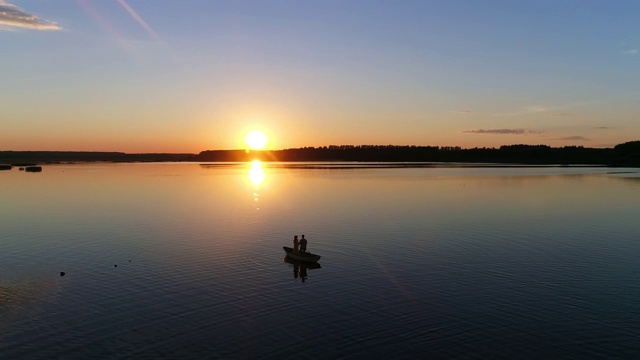 划船的人。湖泊或河流上的日落-无人机镜头视频素材