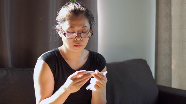 亚洲妇女感到不舒服，因此在家里用温度计测量体温视频下载