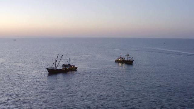 日出时从空中看到海上的拖网渔船视频素材