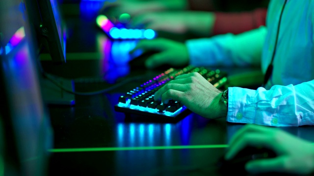 人们在电脑前工作，双手按键盘上的按钮。现代设备，背光键盘。特写镜头。视频素材