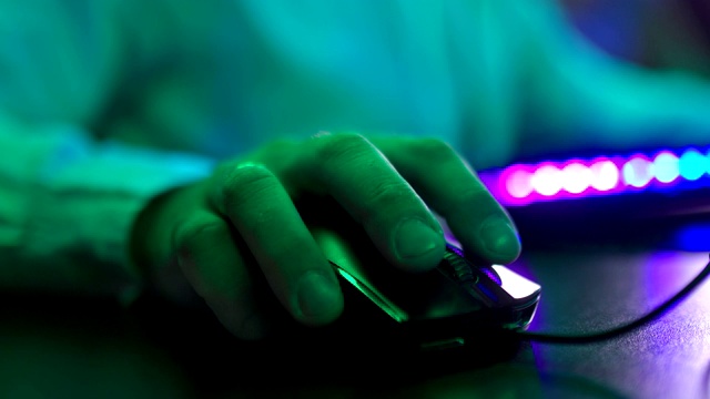 男性的手指握着电脑鼠标并点击按钮。一个人在桌子上移动电脑鼠标。特写镜头。视频素材