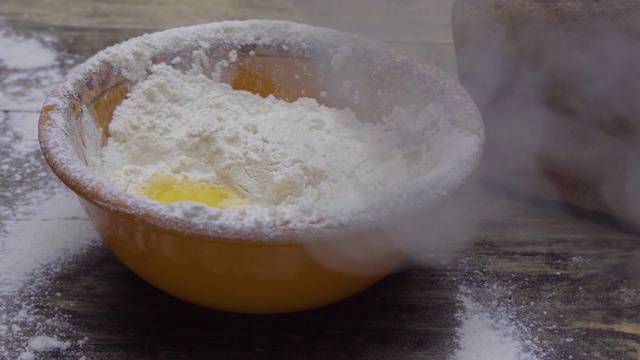 鸡蛋落入面粉中，蛋黄落入面粉中。烘焙产品。烹饪面团视频下载