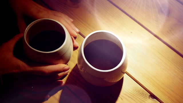 女人的手站在木桌上拿两杯咖啡中的一杯视频素材