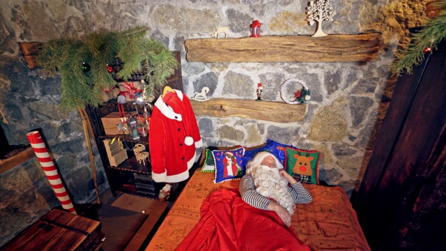圣诞老人睡在特别装饰的房间里的床上。视频下载