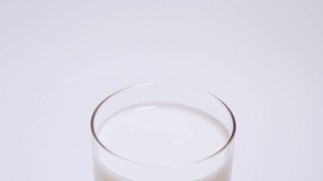一杯椰奶酸奶慢慢出现在画面中。隔离在白色背景4k视频素材