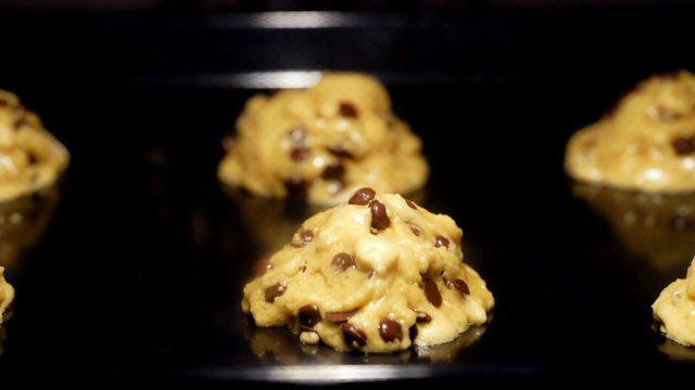 用烤箱烘焙巧克力饼干。融化的面团和巧克力变成新鲜美味的自制点心。时间流逝的视频视频素材