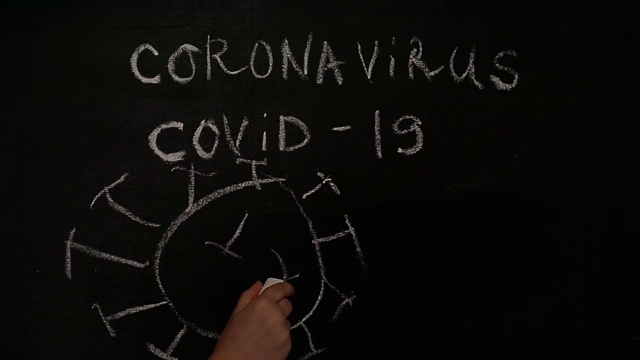 冠状病毒新型冠状病毒肺炎一个孩子的手用粉笔在黑板上画出了想象中的病毒。抗击病毒视频下载