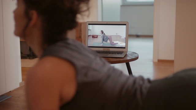 在家上在线瑜伽课的女人视频素材