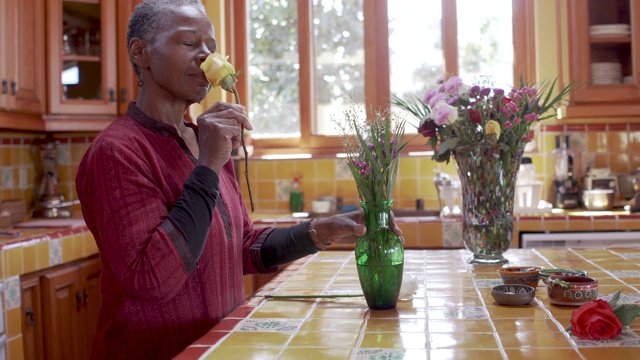 迷人的黑人中年妇女在一个好心情把她的花在一个花瓶视频下载