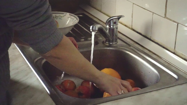 一个女人在厨房的水槽里慢镜头洗新鲜水果视频素材