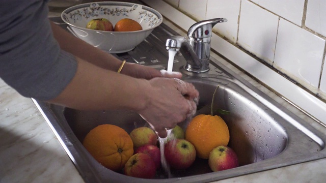 在厨房水槽里洗新鲜水果的女人视频素材