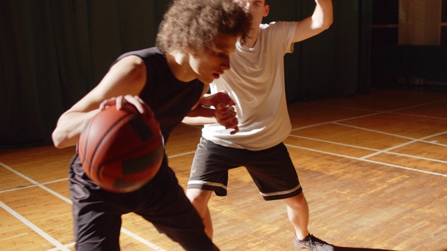 两名篮球运动员近距离对抗，运动耐力，进攻，防守，夜间运动比赛大厅卷发视频下载