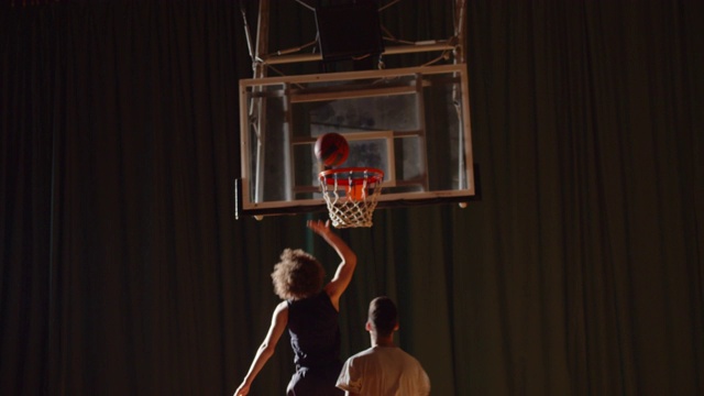 两名年轻的篮球运动员打篮球比赛，业余运动员大厅体育拼花，运球耐力视频下载