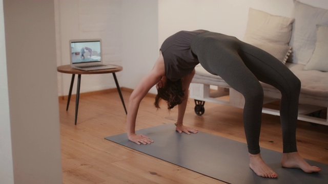在家上在线瑜伽课的女人视频素材