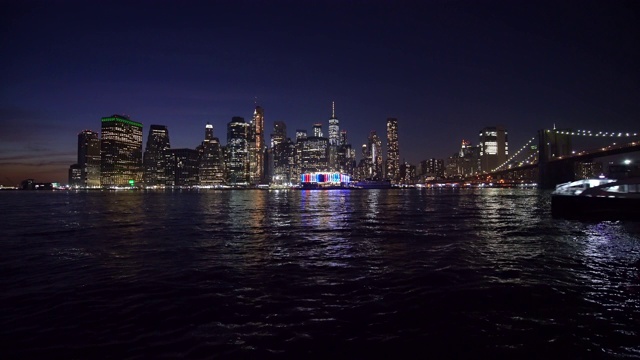 一艘渡船经过/美国纽约，纽约，纽约市的夜景视频素材