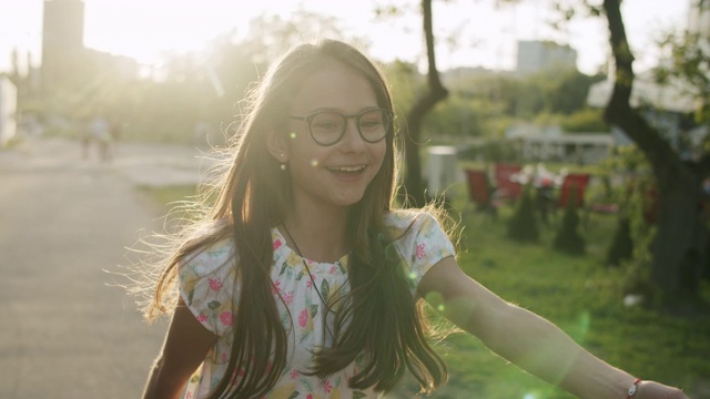 快乐的少女在外面跳。女孩在公园里做有节奏的动作视频下载