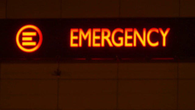 医院大楼夜间急诊科服务红色标志散焦视频素材