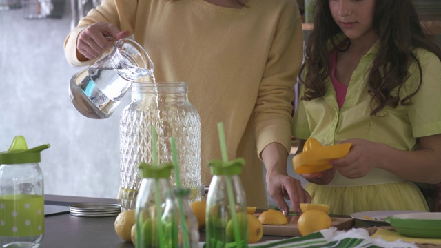 母亲和女儿一起准备美味清爽的柠檬水视频下载
