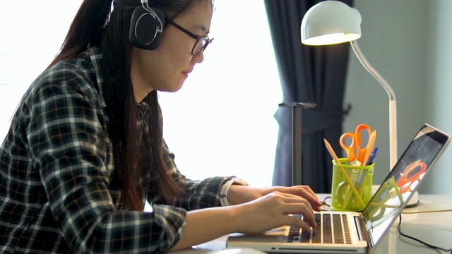 亚洲女性在家里使用笔记本电脑。视频素材