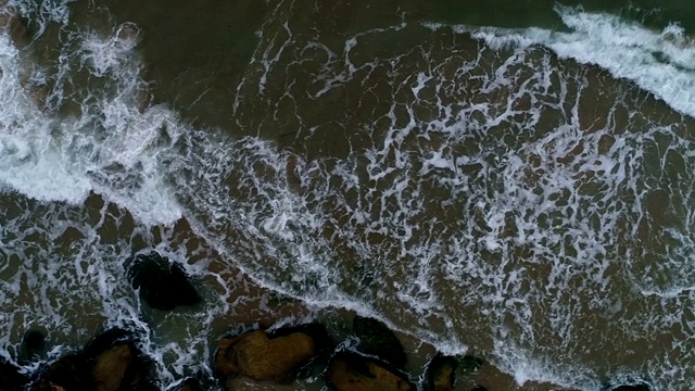 泡沫状的海浪翻滚着涌向沙滩视频素材