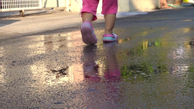 两个孩子在潮湿的街道上奔跑视频素材