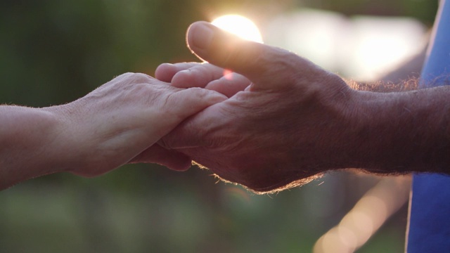 一对深情的老夫妇在日落时牵着手视频素材