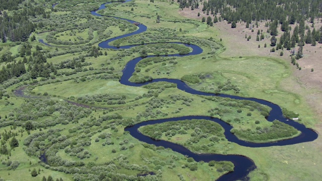 鸟瞰图的小德舒特河蜿蜒通过葱翠的景观，德舒特县，俄勒冈州。视频下载