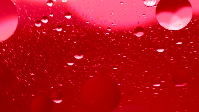 红色的油滴在水面抽象的背景。气泡在液体中的运动，气泡微距拍摄。特写水中的气泡。抽象的手机主屏幕风格，主题或背景视频素材