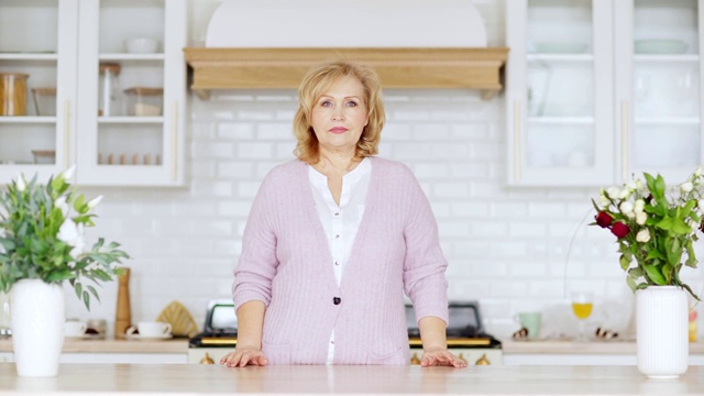腰上正面的观点肖像严肃的高级妇女看了在美丽的家庭厨房餐桌视频下载