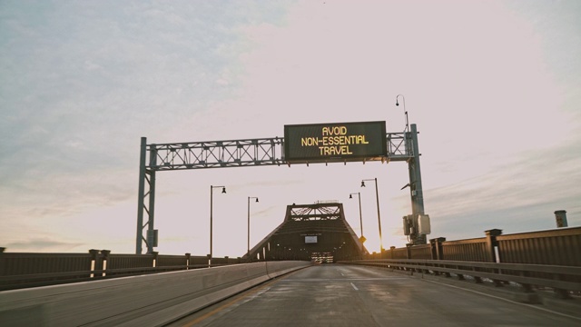 由于COVID-19冠状病毒在新泽西州大流行，普拉斯基将军天桥上的路标闪烁着“避免非必要旅行”的警告。司机的观点。视频素材
