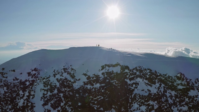 71、登山运动员站在雪山的顶端，阳光高照山顶，高地全景视频素材
