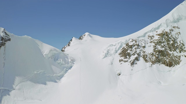 全景，耀眼的雪山，登山家征服了巨大的冰冻斜坡视频素材