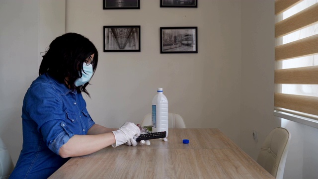 成熟女子清洁遥控器用消毒剂自我隔离和预防冠状病毒的概念视频素材