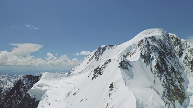 高空全景，巨大的雪山在蓝天映衬下闪耀视频素材
