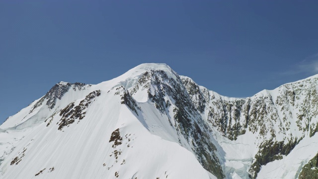 空中全景，雪山山顶，山坡上全是白雪，天空湛蓝视频素材