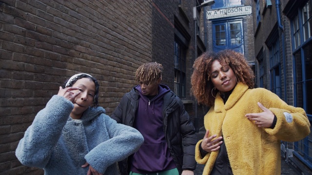 三个嘻哈朋友在城市户外一起跳舞的慢动作视频视频素材
