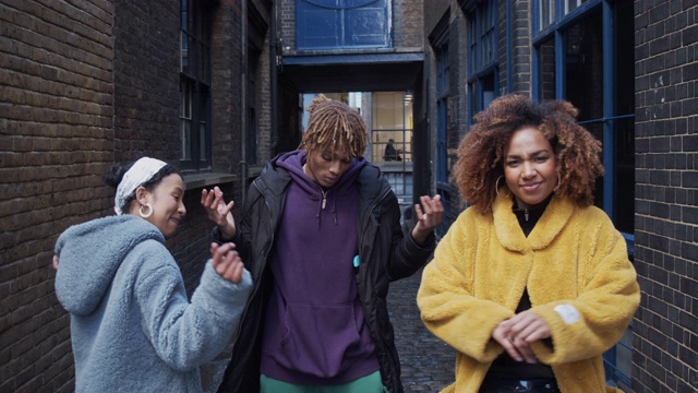 三个嘻哈朋友在城市户外一起跳舞的慢动作视频视频素材