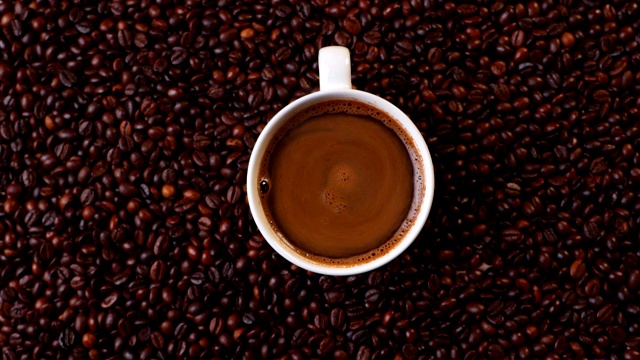 顶视图白杯黑咖啡上的咖啡豆视频下载