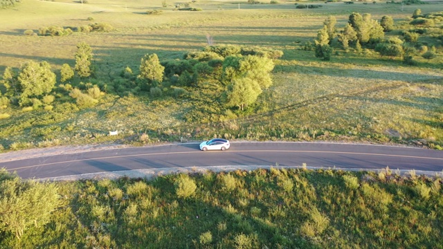 4K交通鸟瞰图白色汽车行驶在乡村道路上视频素材