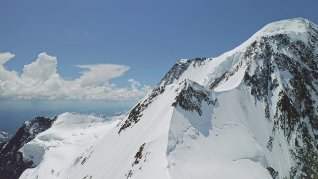 雄伟的高原全景，雪山山峰高耸在阳光灿烂的天空与云彩视频素材