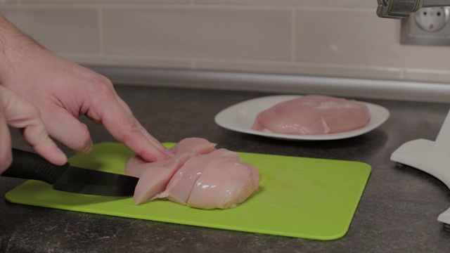 一个男人在砧板上切鸡胸肉视频下载